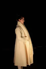 Tapado largo color crudo, confeccionado en lana merino afieltrada. Presenta cuello alto y guarda tejida en el cuello y ruedo. Tiene un estampado de una luna en la espalda.