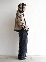 Hoodie con cierre frontal, confeccionado en tejido de punto 100% algodón. Es una prenda reversible con diseño de estampado gráfico en mangas y capucha, y presenta detalles de roturas intencionales en puños, ruedo y bolsillos.