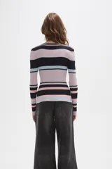 Remera de manga larga confeccionada en tejido de punto acanalado con diseño de rayas horizontales en tonos azul marino, rosado y celeste. Presenta un cuello redondo a la base con una pequeña abertura frontal cerrada por una hilera de botones.