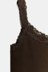 Top de tirantes negro confeccionado en mezcla de algodón, con escote redondo adornado con detalles de encaje a tono.