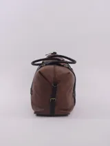 Bolso de viaje tipo duffle, confeccionado en cuero natural color azul con textura, con detalles de correas y asas en cuero color suela. Cuenta con cierre superior, bolsillo interior con cierre y compartimento para celular.