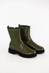 Borcegos de cuero color verde oliva, con caña media, cierre lateral interno y suela track negra de goma.