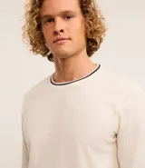 Sweater de manga larga color azul marino con textura acanalada vertical. Presenta un cuello redondo con un ribete blanco contrastante y un borde inferior con un detalle blanco asomando.