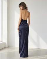 Vestido largo de satén color azul marino, con cuello halter, aberturas frontales y diseño fluido que estiliza la figura.