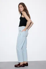 Top negro de punto rib con cuello halter, sin mangas y detalles de encaje a tono en las sisas.