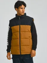 Chaleco puffer Caterpillar Arctic Zone Vest, diseño bicolor en negro en la parte superior y marrón (tostado) en la inferior, con cuello alto, cierre frontal y bolsillos laterales con cierre.