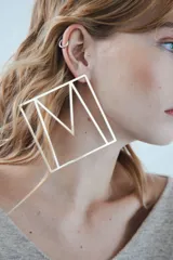 Aro dorado con forma de letra M dentro de un cuadrado.