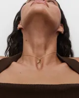 Collar de plata con baño de oro, con una cadena de eslabones y un colgante en forma de letra "A" estilizada que incluye una circonita engastada.