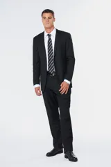 Traje clásico negro de corte fit, compuesto por saco de botonadura simple con bolsillos con solapa y pantalón de vestir a juego.
