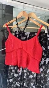 Falda midi de corte recto, confeccionada en tela satinada con textura arrugada en color bordó. Presenta un diseño elegante y fluido.