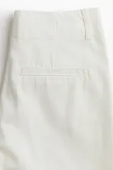 Pantalón de jean blanco de corte wide leg y tiro alto, con diseño de pierna amplia, bolsillos laterales al bies y raya marcada en el frente.