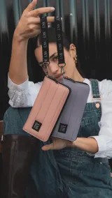 Billetera larga con cierre perimetral, confeccionada en nylon capitoneado color verde petróleo. Cuenta con correa de mano desmontable con logo estampado y parche frontal con marca LNS.