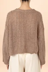 Cardigan de punto color marrón con sutiles destellos brillantes, cuello en V, cierre frontal con botones y mangas largas abullonadas con puños ajustados.