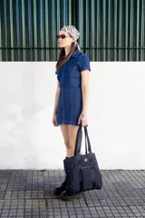 Vestido corto de denim azul con cierre frontal completo, cuello camisero y mangas cortas.