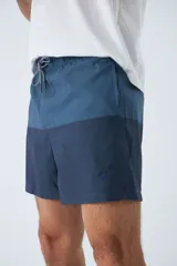 Short de baño con estampado de líneas curvas en tonos azules, cintura elástica con cordón ajustable, bolsillos laterales y bolsillo trasero. Incluye suspensor interno y logo bordado.
