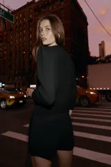 Chaqueta de punto color negro con cuello redondo, manga por debajo del codo con hombros marcados y acabados en rib. Cierre frontal con botones dorados.