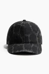 Gorra de sarga de algodón con efecto lavado y estampado de leopardo. Presenta ojales bordados, cinta antitranspirante interior y trabilla ajustable con cierre metálico en la parte posterior.