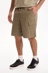 Bermuda cargo negra con cintura elastizada y cordón ajustable, de corte holgado y bolsillos laterales con solapa.