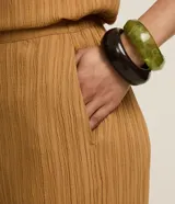 Pantalón recto color ocre con textura acanalada, de cintura alta con elástico y bolsillos laterales.