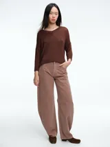 Sweater de punto con brillo, de corte relajado y escote en V. Presenta hombros caídos y mangas largas con puños acanalados.