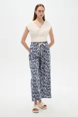 Pantalón de algodón estampado con diseño botánico en tonos de azul, corte holgado, tiro medio y cintura elástica con cordón de ajuste.