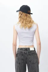 Top sin mangas negro, ajustado al cuerpo, con cuello redondo y tejido acanalado. Presenta un pequeño estampado frontal de una frutilla con el texto "berry cute".