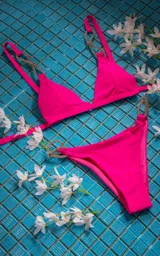 Conjunto de bikini fucsia con corpiño triangular y bombacha clásica con argollas plateadas con strass en los laterales.