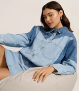 Campera de jean con diseño bicolor, confeccionada en algodón. Presenta cuello polo, cierre frontal con botones, mangas largas y bolsillos aplicados en el frente con recortes estructurados.