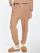 Pantalón de dormir de tela acanalada con diseño de rayas horizontales finas. Presenta cintura elastizada con cordón ajustable, bolsillos laterales y puños elásticos en los tobillos.
