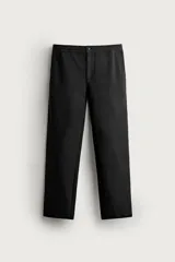Pantalón negro confeccionado en mezcla de algodón, con cintura elástica, bolsillos frontales y cierre con cremallera y botón.