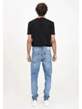Jeans de hombre Calvin Klein, corte slim taper, color azul claro con efecto desteñido y lavado. Presenta diseño de cinco bolsillos y herrajes con insignia de cuero en la parte posterior.