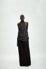 Top halter de viscosa con estampado de lunares, cuello halter, espalda descubierta y detalle de lazadas en el mismo tejido. Cuenta con bajo redondeado y cierre trasero con botones.