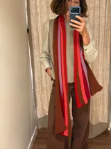 Bufanda de lana tejida en punto acanalado con diseño de rayas verticales en tonos marrones, rojos, fucsias y lilas.
