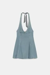 Vestido corto de denim con escote halter y cuello en pico, tirantes cruzados para atar en el cuello y falda acampanada con pliegues.