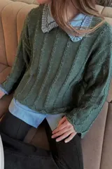 Sweater de tejido de punto con textura acanalada y acabado brillante, de corte holgado y largo a la cadera, con mangas largas y cuello redondo.