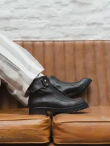 Bota corta de cuero color marrón oscuro con hebilla lateral y suela track.