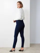 Jean skinny de tiro alto, color azul oscuro, con pretina con pasadores, botón y cierre. Delantera con tres bolsillos, dos simulados y uno aplicado. Trasera con bolsillos aplicados.