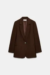 Blazer de mujer color marrón oscuro, con cuello solapa, manga larga y un solo botón de cierre frontal. Presenta bolsillos de vivo en el delantero.