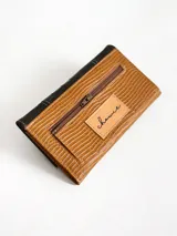 Billetera de cuero combinada en color negro y camel, con diseño de solapa con textura de cocodrilo y detalles de costuras en forma de X. Cuenta con cierre de broche y monedero externo.