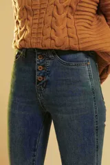 Pantalón de jean corte regular, tiro alto con cierre de botones a la vista, en tono azul clásico con efecto lavado.