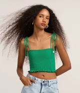 Top cropped femenino de color verde, confeccionado íntegramente en tejido lastex fruncido. Presenta un escote cuadrado y breteles finos regulables mediante lazos con detalle de concha en las puntas.
