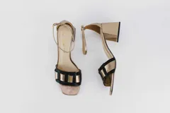 Sandalias doradas con taco bloque de 5 cm y capellada combinada en dorado y negro.