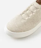 Championes casuales de knit en color beige con suela blanca y detalles en cuero sintético marrón en el talón y la lengüeta.