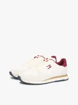 Zapatillas runner Tommy Jeans Eva de estilo urbano, confeccionadas en una combinación de cuero blanco, textil y material sintético. Presentan detalles en color bordó en el talón y el interior, entresuela con franja marrón y suela dentada azul. Cuentan con el logo de Tommy Jeans bordado en el lateral.