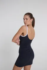 Vestido corto negro de estilo deportivo, confeccionado en tejido Activelu, con tirantes blancos y corte ajustado.