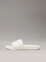 Ojotas Calvin Klein con tira ancha de tejido jacquard que presenta el logo de la marca en relieve. Poseen plantilla ergonómica moldeada con soporte para el arco y suela de EVA.