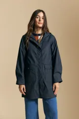 Pilot de largo medio color azul marino, con capucha integrada, cierre frontal oculto y bolsillos aplicados con tapa. Presenta una silueta recta y diseño funcional.