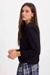 Remera de manga larga color blanco, con cuello redondo y corte holgado. Presenta un pequeño bordado en el centro del pecho.