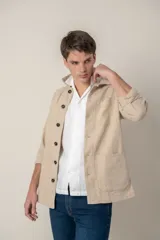 Sobre camisa color verde militar de lino con cuello clásico, manga larga con puños abotonados, cierre frontal con botones a tono y bolsillos de parche en el pecho.