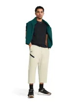 Pantalón deportivo tipo capri de Under Armour, confeccionado en tejido de doble punto elástico y transpirable. Presenta un diseño holgado con cintura elástica, bolsillos laterales abiertos y un bolsillo adicional con cierre en la pierna derecha. Incluye el logo de la marca en el muslo.